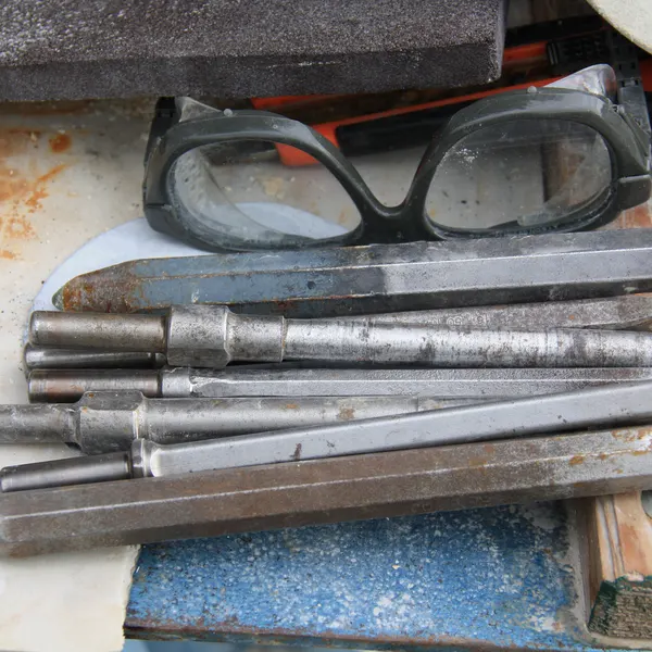 Meißel und Schutzbrille auf der Werkbank